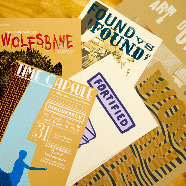 Screenprinted posters and flyers on a plywood background.